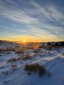 A colorful sunrise over a blustery winter landscape.