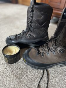 A pair of Zamberlan hunting boots next to a jar of oil.
